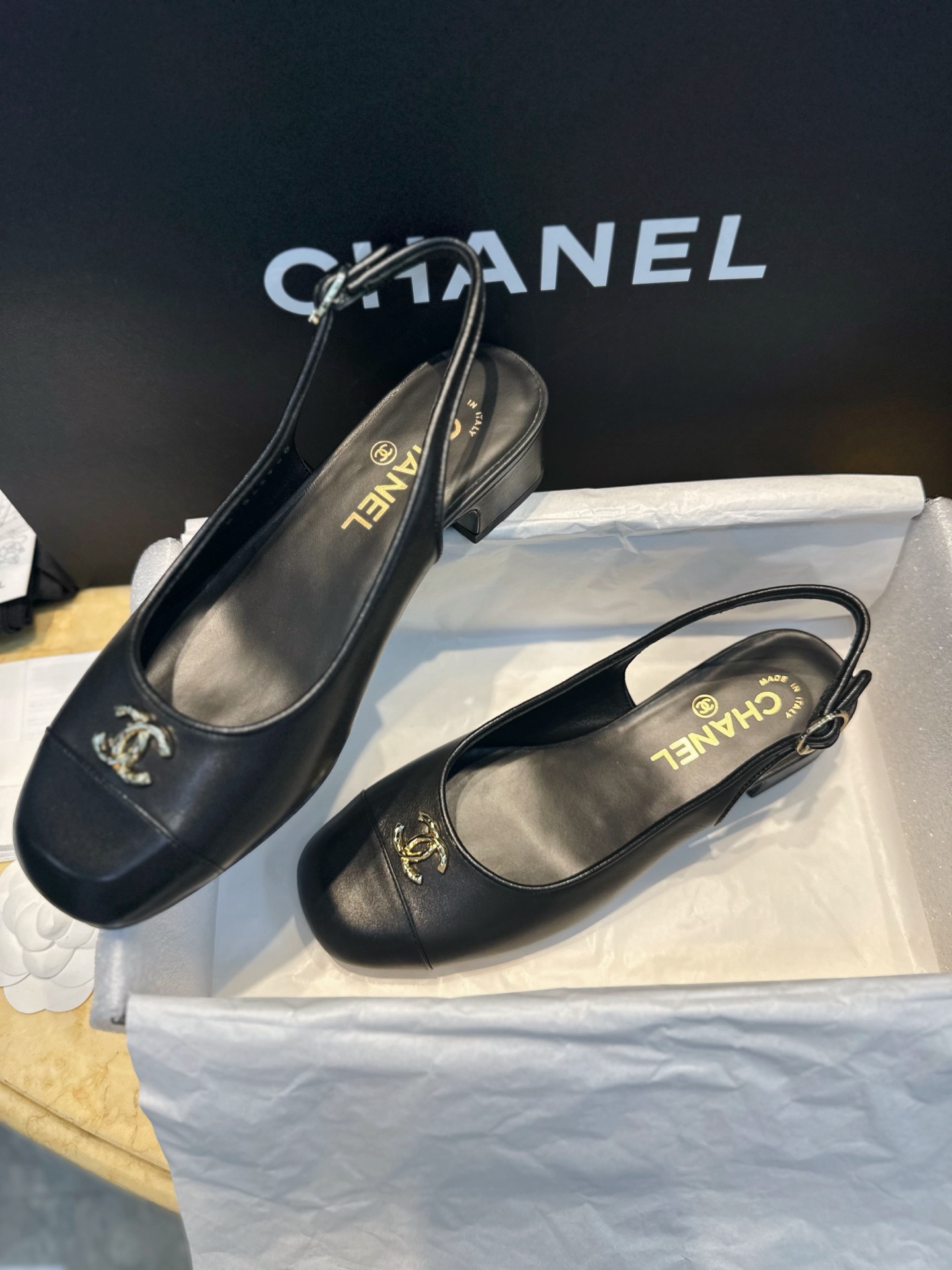 Bagsaaa Ch**el slingback pumps in black leather with a gold-tone CC logo