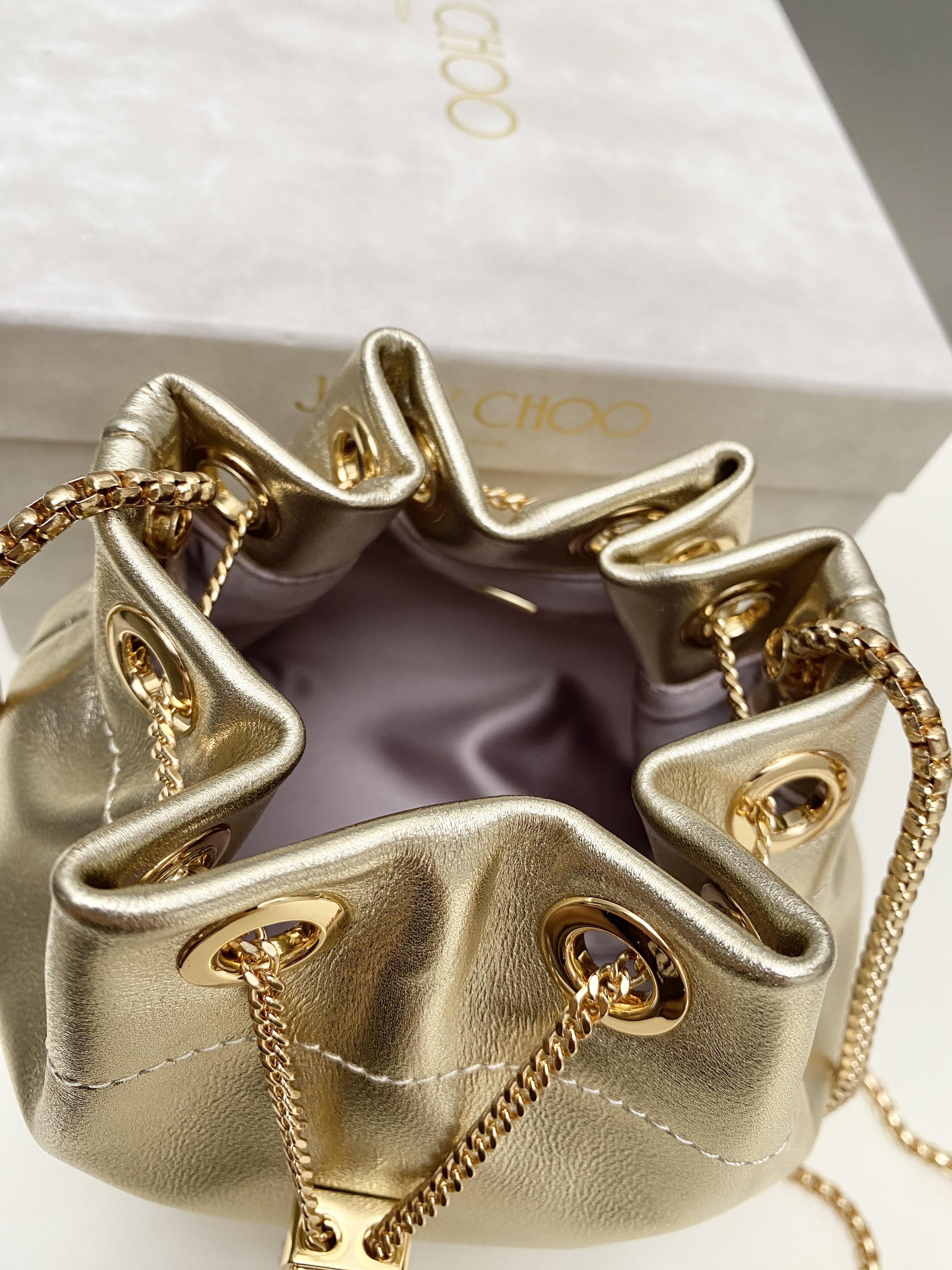 Bagsaaa J1m*y Ch00 Bon Bon Micro leather bucket bag in a gold metallic - 16cm