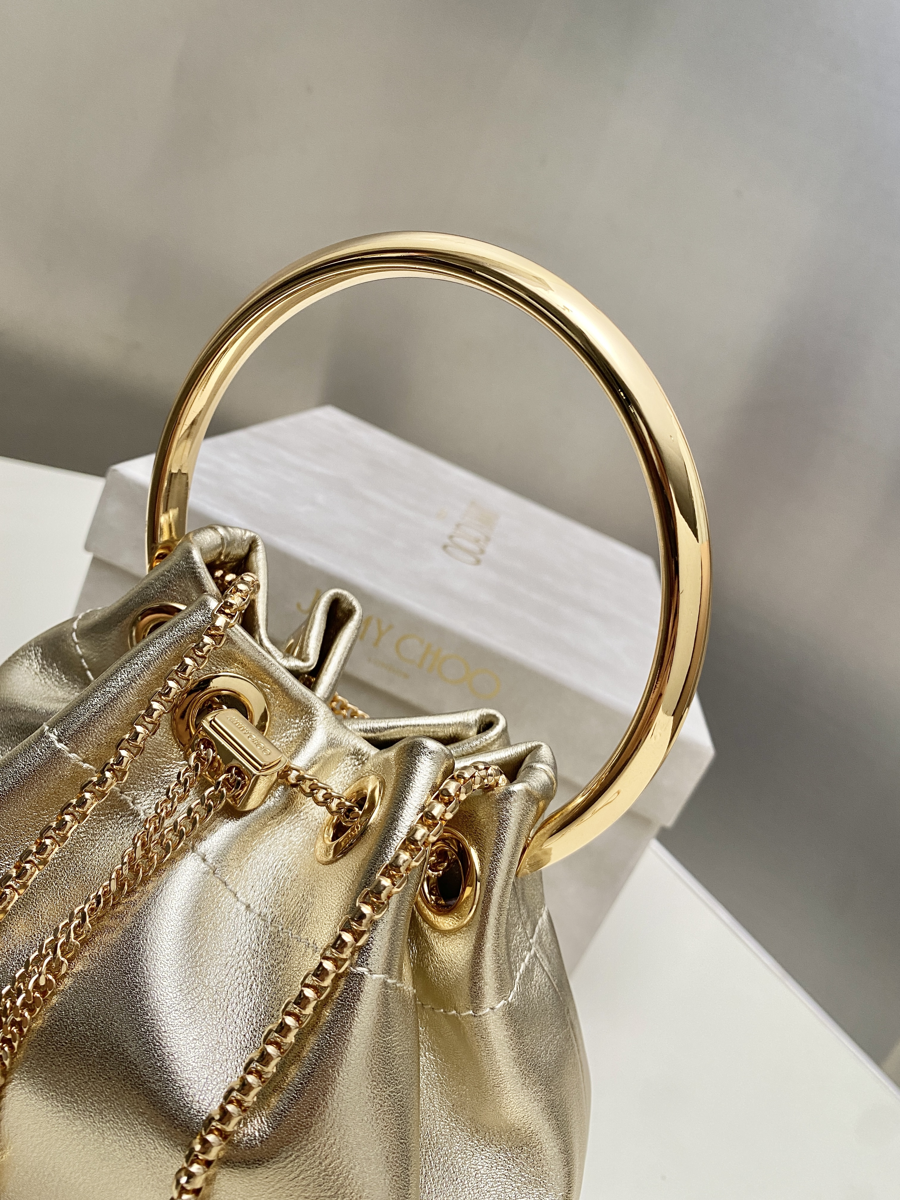 Bagsaaa J1m*y Ch00 Bon Bon Micro leather bucket bag in a gold metallic - 16cm